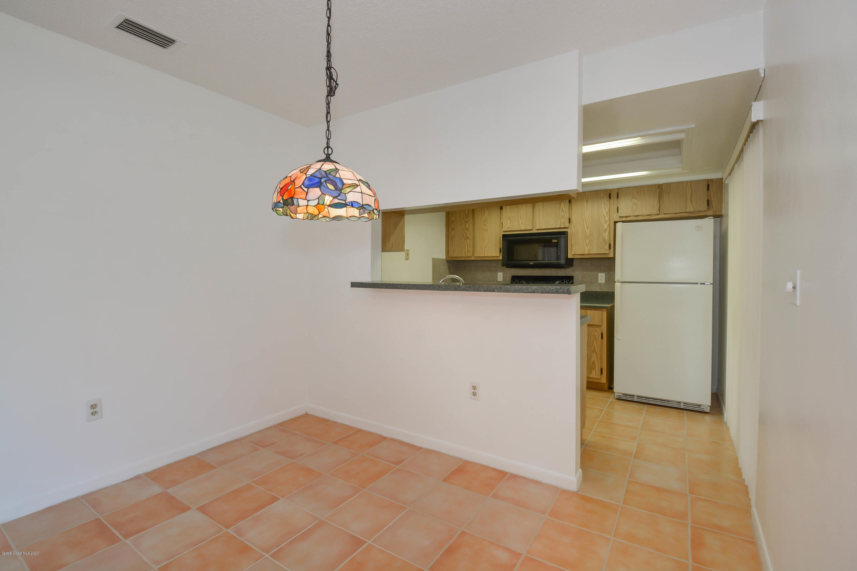 610 North Wickham Road, Unit 74 Melbourne, FL 32935 - Photo 10 of 46 a kitchen with stainless steel appliances a refrigerator and a microwave