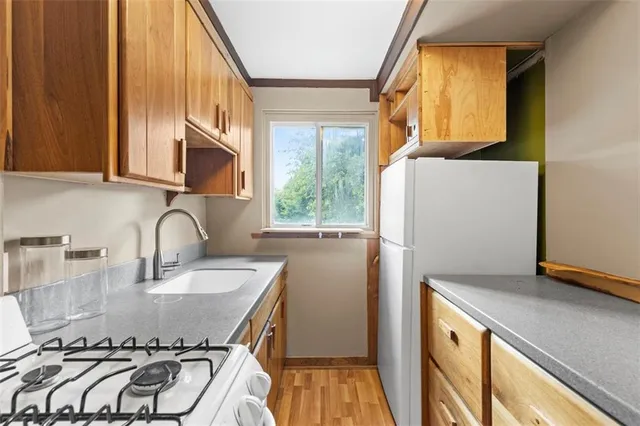 a kitchen with a sink a refrigerator and a stove