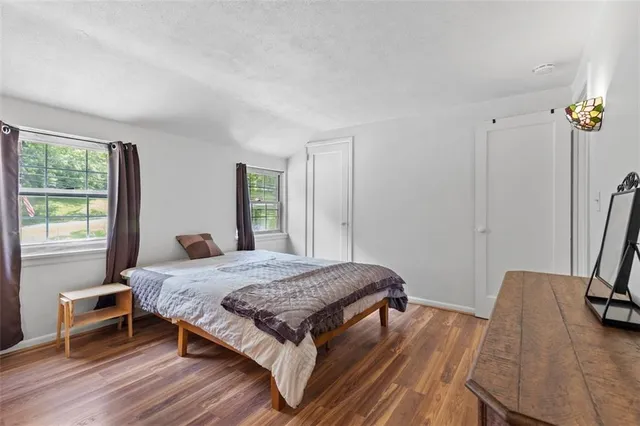 a bedroom with a bed and a lamp on dresser