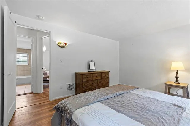 a bedroom with a bed and wooden floor