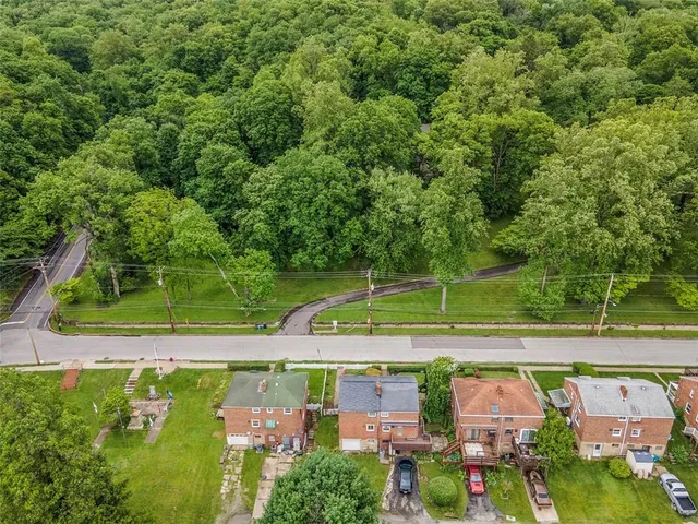 an aerial view of a house with a garden and trees