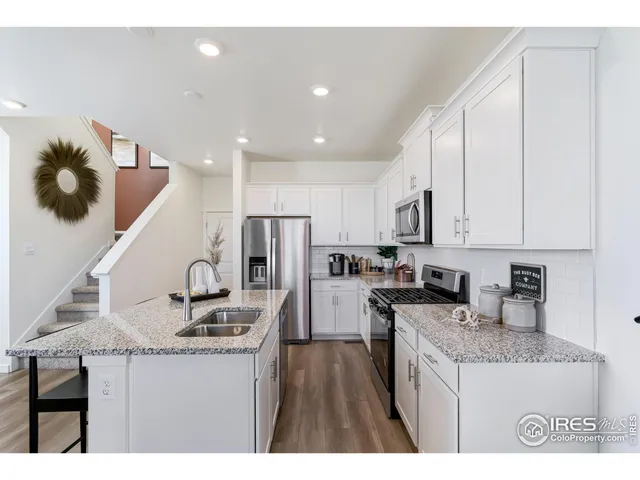 a kitchen with kitchen island granite countertop a sink stainless steel appliances and cabinets