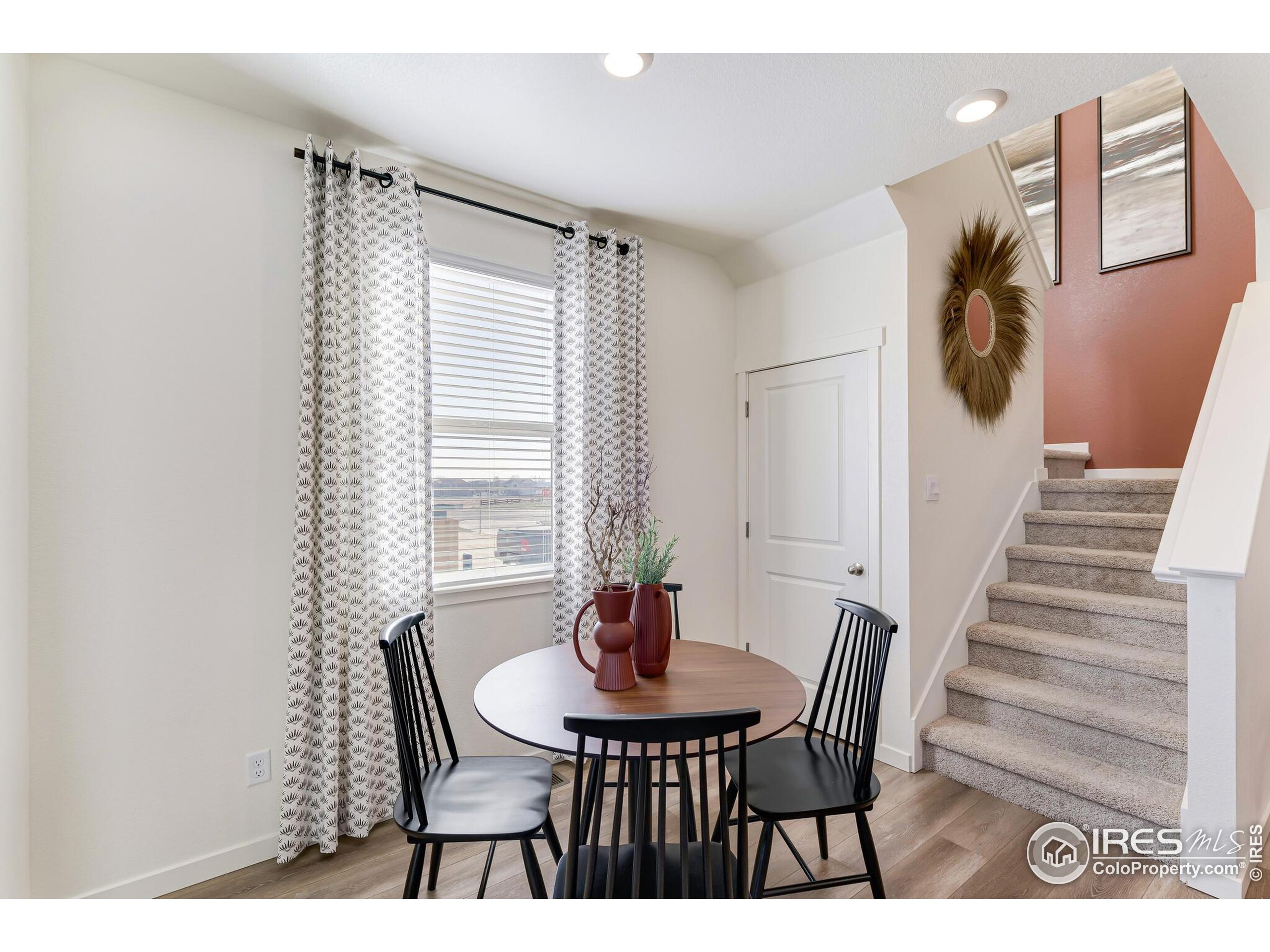 920 Logan Peak Way Berthoud, CO 80513 - Photo 13 of 35 a view of a dining room with furniture and wooden floor