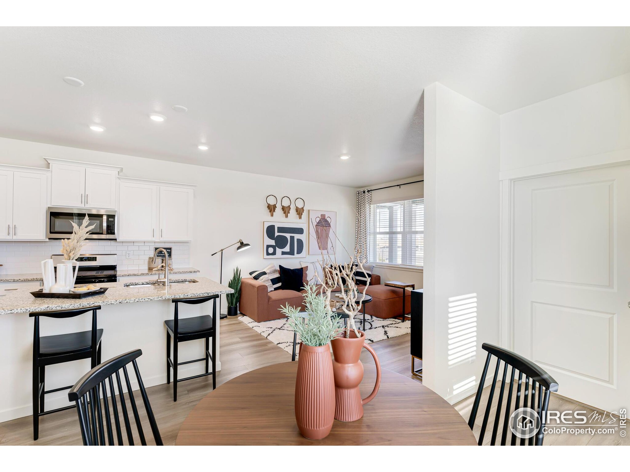 920 Logan Peak Way Berthoud, CO 80513 - Photo 15 of 35 a view of a dining room with furniture and a kitchen
