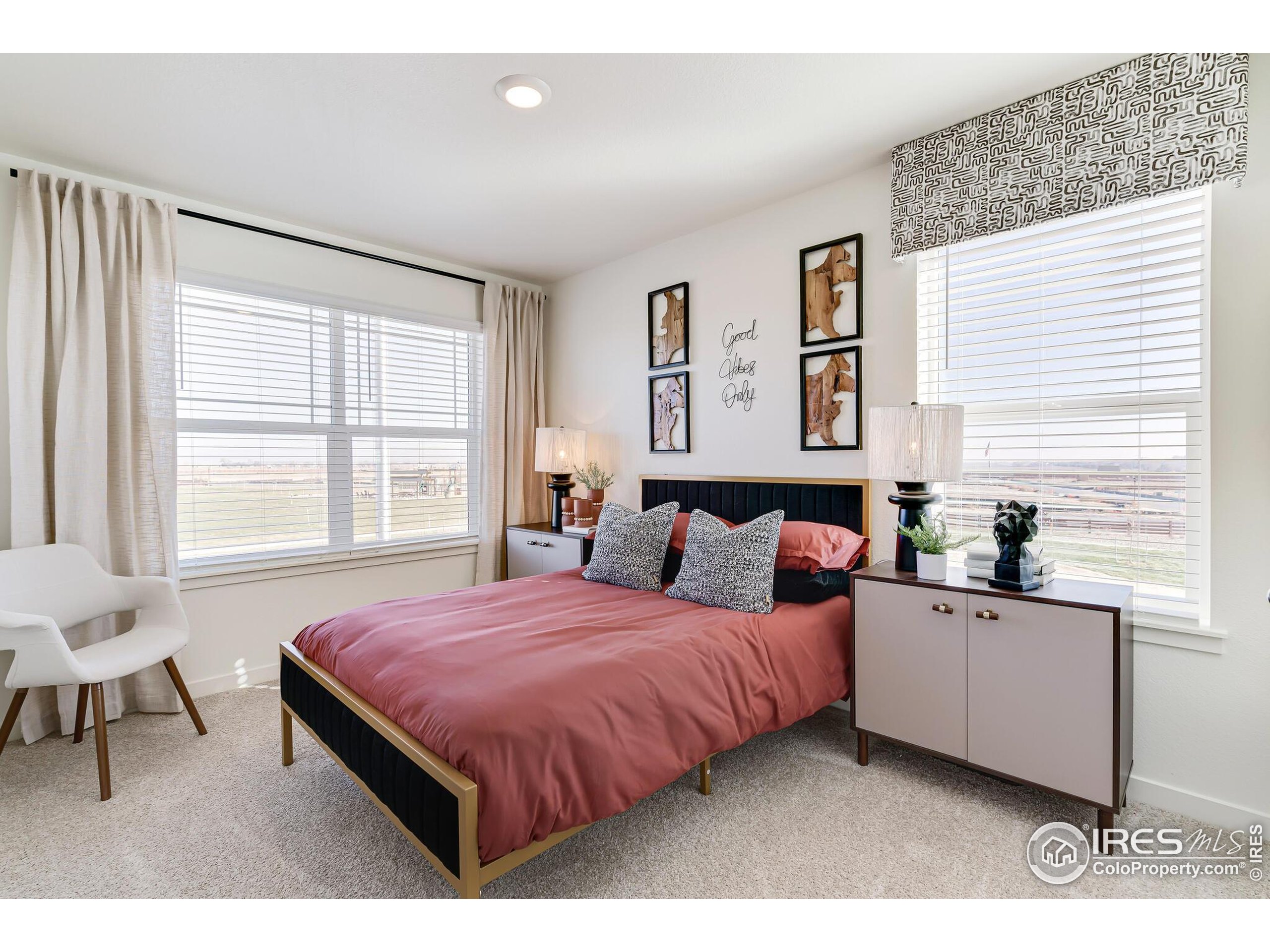920 Logan Peak Way Berthoud, CO 80513 - Photo 24 of 35 a bedroom with a bed and a table in it with wooden floor
