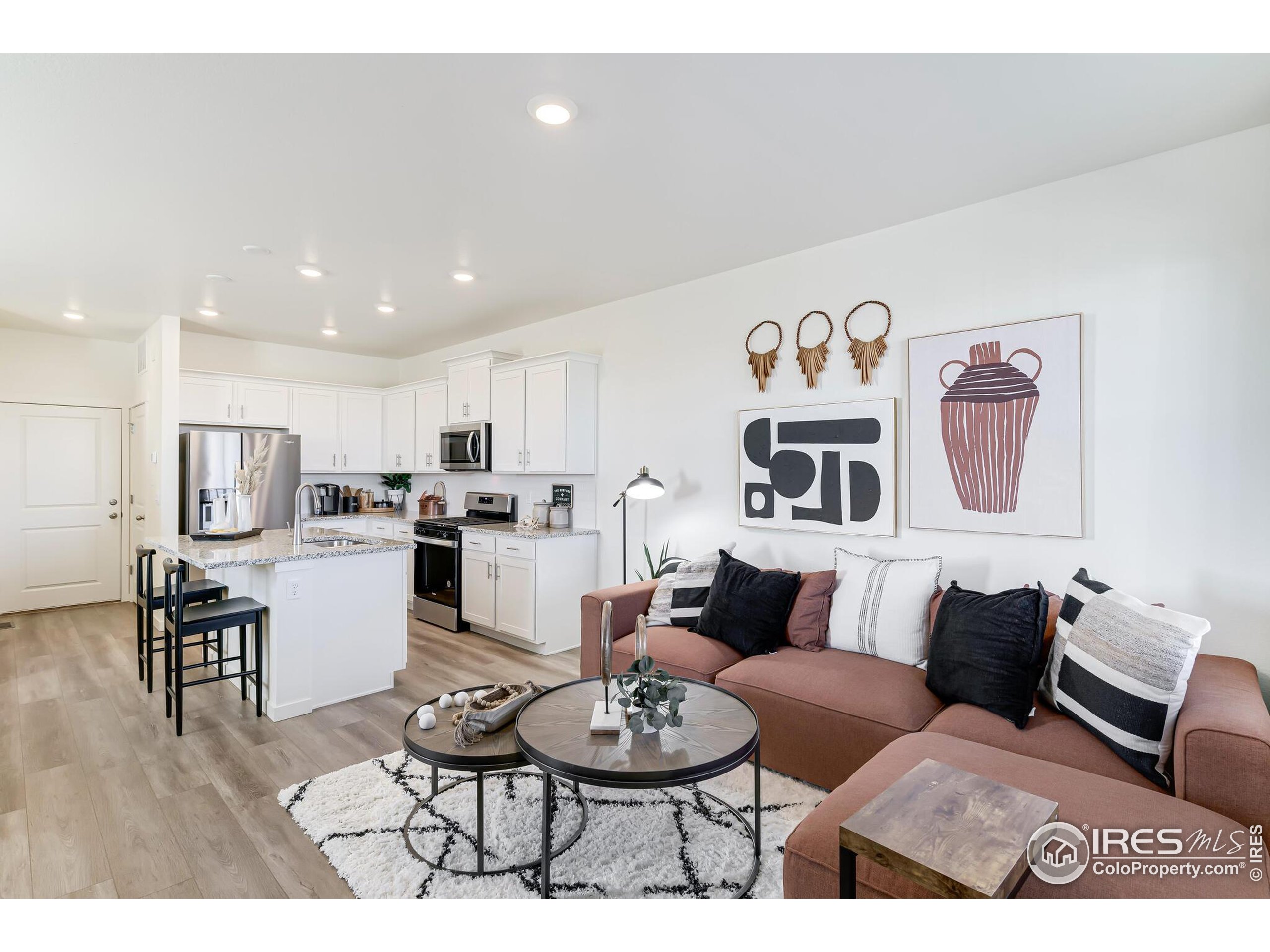 920 Logan Peak Way Berthoud, CO 80513 - Photo 3 of 35 a living room with furniture and kitchen view
