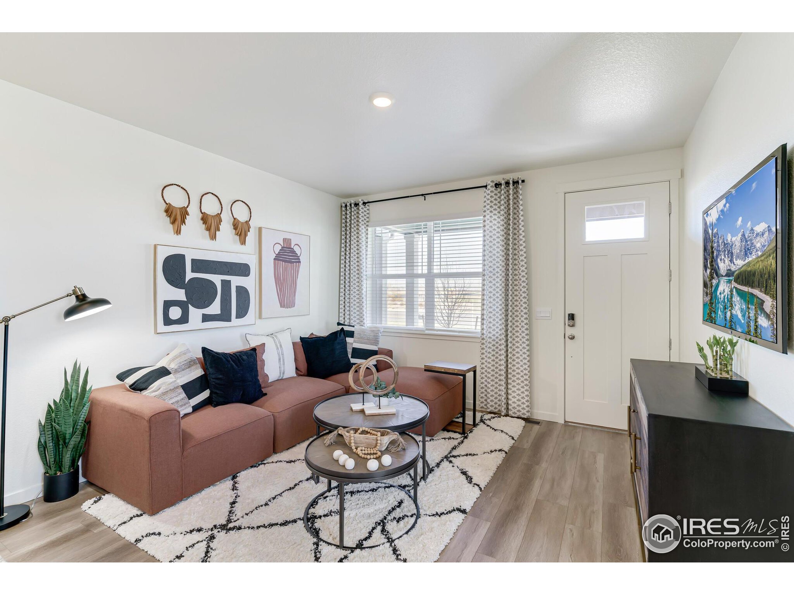 920 Logan Peak Way Berthoud, CO 80513 - Photo 6 of 35 a living room with furniture and a flat screen tv