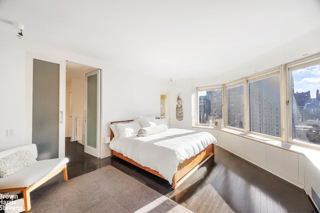 a bedroom with a bed and a large window