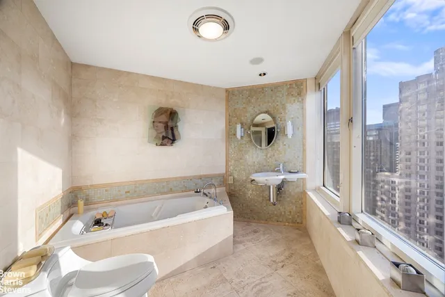 a bathroom with a tub a toilet and a shower