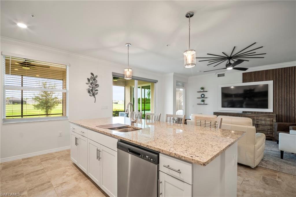 15919 Grassland Lane, Unit 4211 Babcock Ranch, FL 33982 - Photo 12 of 35 a kitchen with granite countertop a sink a counter top space and living room area