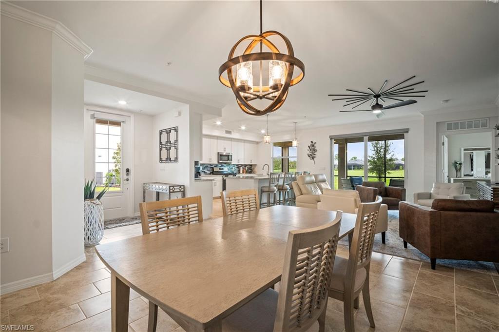 15919 Grassland Lane, Unit 4211 Babcock Ranch, FL 33982 - Photo 8 of 35 a dining room with wooden floor a chandelier a wooden table and chairs