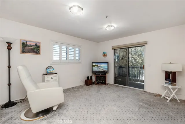 a living room with furniture a flat screen tv and a large window