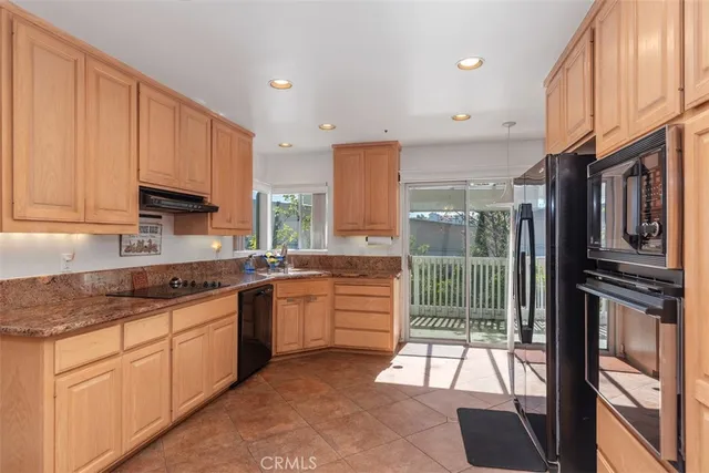a kitchen with stainless steel appliances granite countertop a stove a sink and a refrigerator