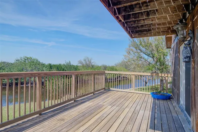 a view of balcony with wooden floor and fence