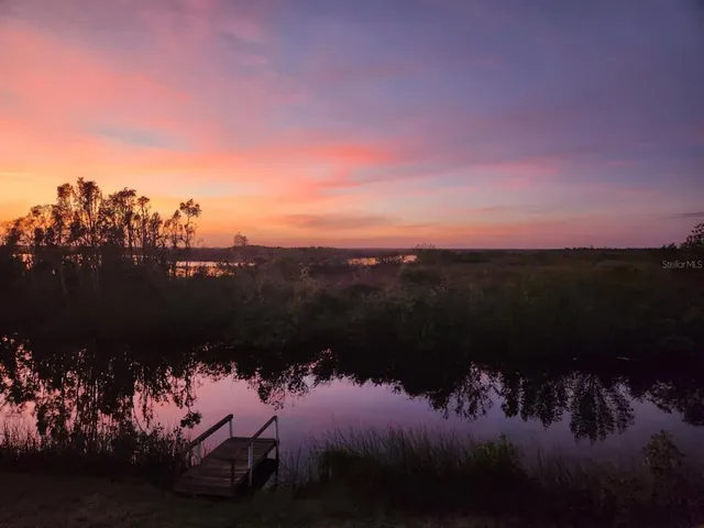 a view of a lake in middle of sunset