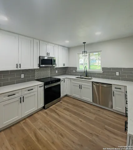 a kitchen with granite countertop cabinets stainless steel appliances and a window