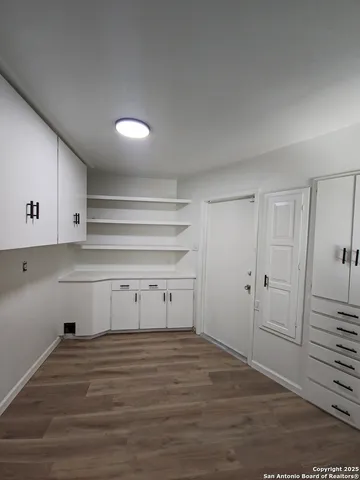 a view of a room with wooden floor and cabinet