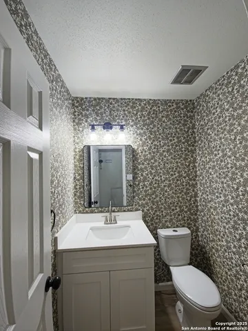 a bathroom with a toilet a sink and mirror