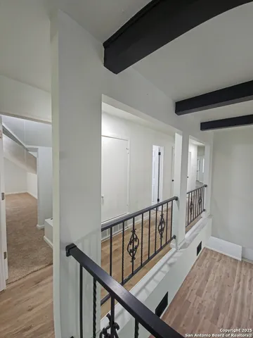 a view of a hallway with wooden floor and stairs