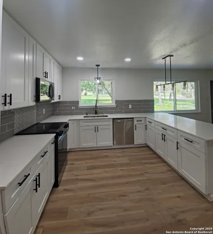 a large kitchen with cabinets a sink and appliances