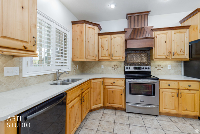 2327 Bluff Ridge Drive Syracuse, UT 84075 - Photo 15 of 66 Kitchen featuring knotty pine cabinetry, a stainless steel range with a decorative wood hood, light-toned countertops, a tile backsplash, and ceramic tile flooring
