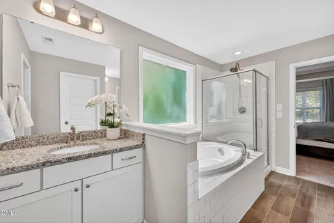 a bathroom with a tub a sink and a window