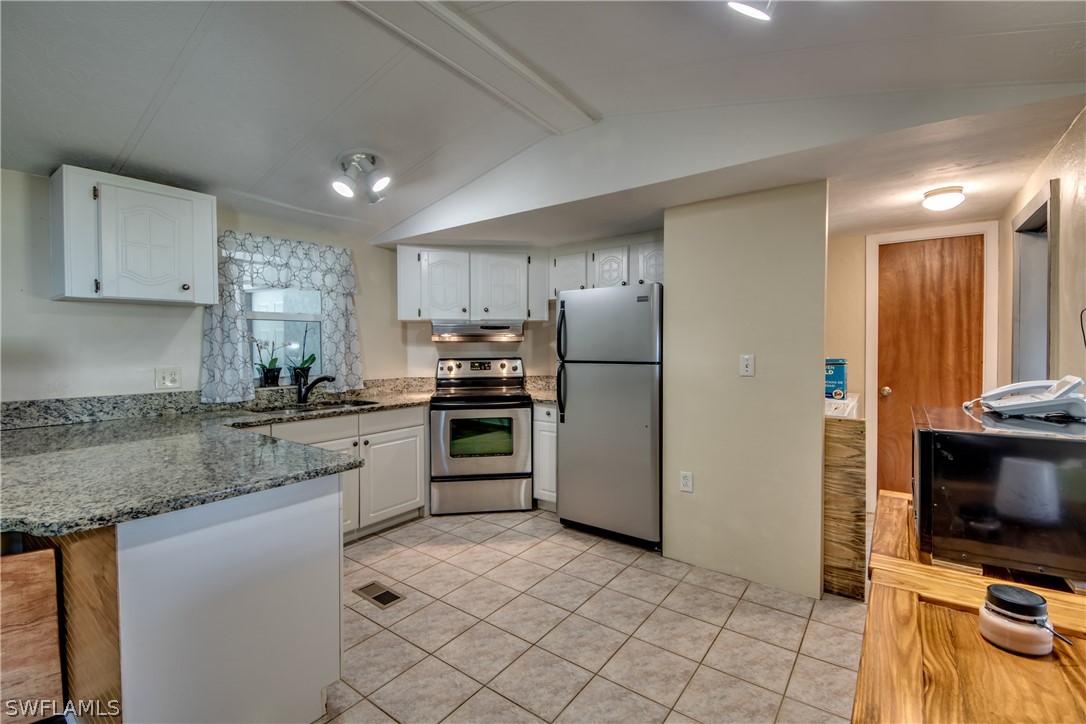 13781 Rod And Gun Club Road Fort Myers, FL 33913 - Photo 5 of 35 a kitchen with granite countertop a refrigerator and a stove top oven