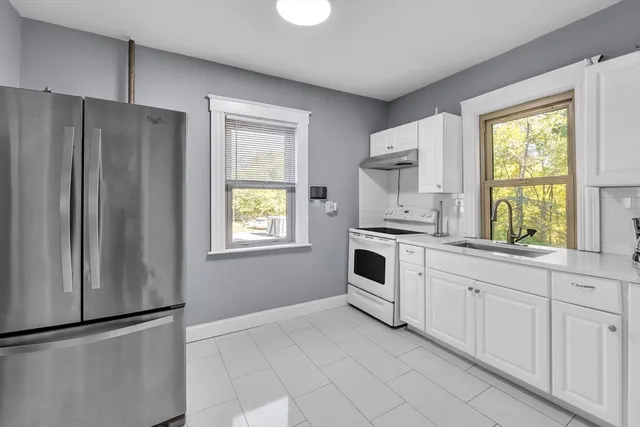 a kitchen with granite countertop white cabinets and white appliances