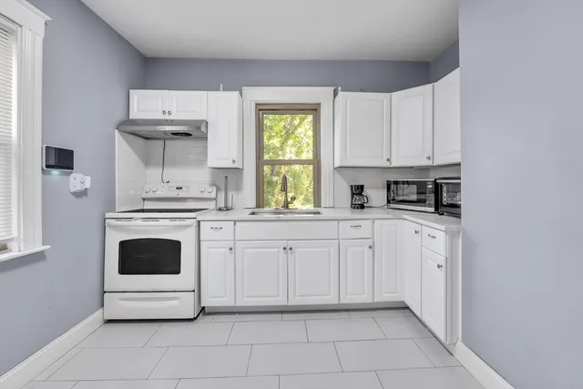 a kitchen with white cabinets and white appliances