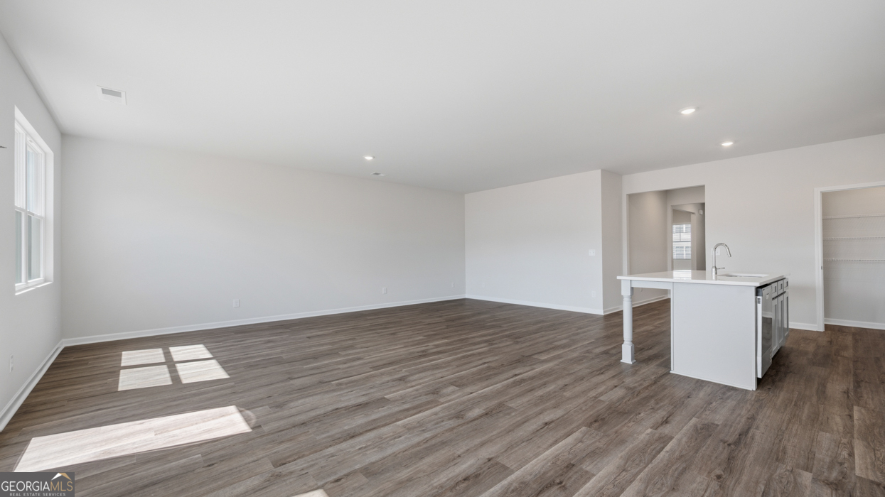 8583 Preakness Pass Snellville, GA 30039 - Photo 14 of 30 a view of empty room with wooden floor and fan