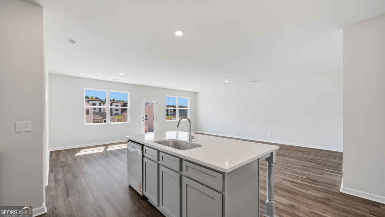 8583 Preakness Pass Snellville, GA 30039 - Photo 16 of 30 a kitchen with a sink cabinets and wooden floor