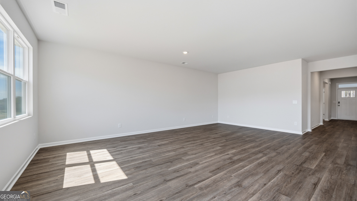 8583 Preakness Pass Snellville, GA 30039 - Photo 17 of 30 an empty room with wooden floor and windows