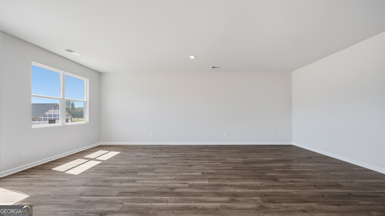 8583 Preakness Pass Snellville, GA 30039 - Photo 18 of 30 a view of empty room with wooden floor and fan
