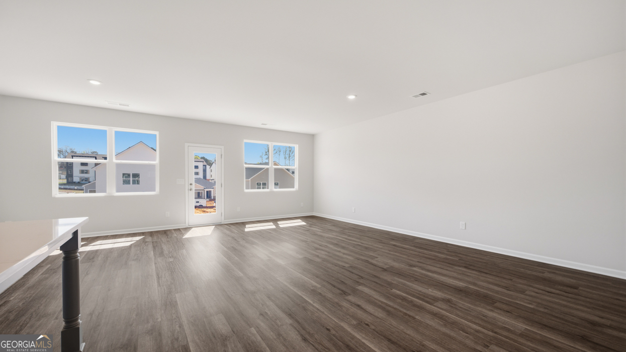 8583 Preakness Pass Snellville, GA 30039 - Photo 19 of 30 a view of an empty room with wooden floor and a window