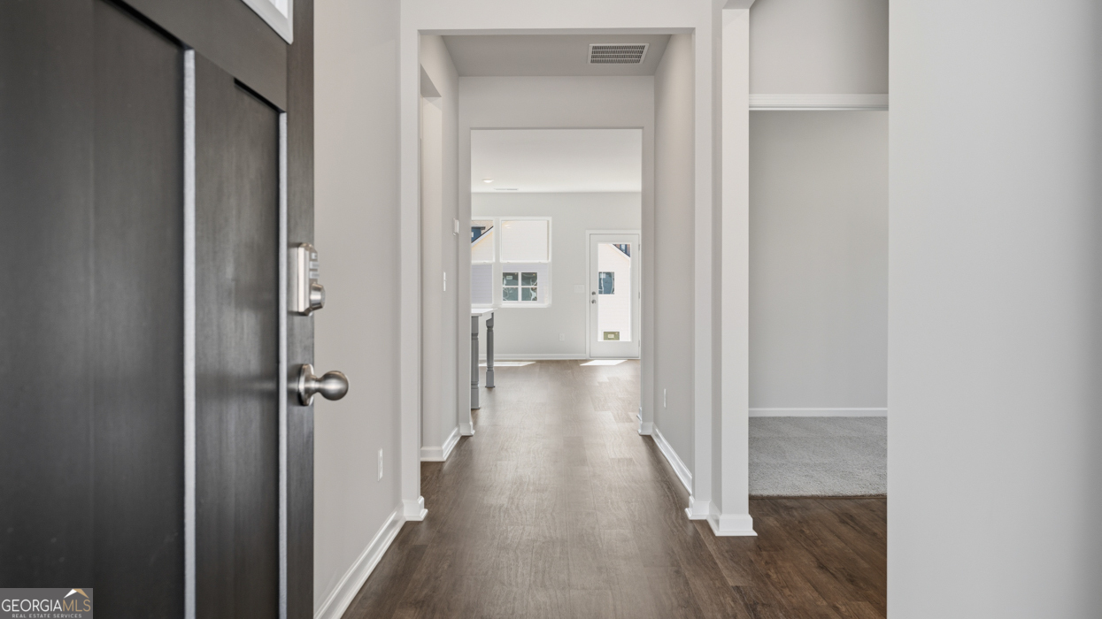 8583 Preakness Pass Snellville, GA 30039 - Photo 2 of 30 a view of a hallway with wooden floor