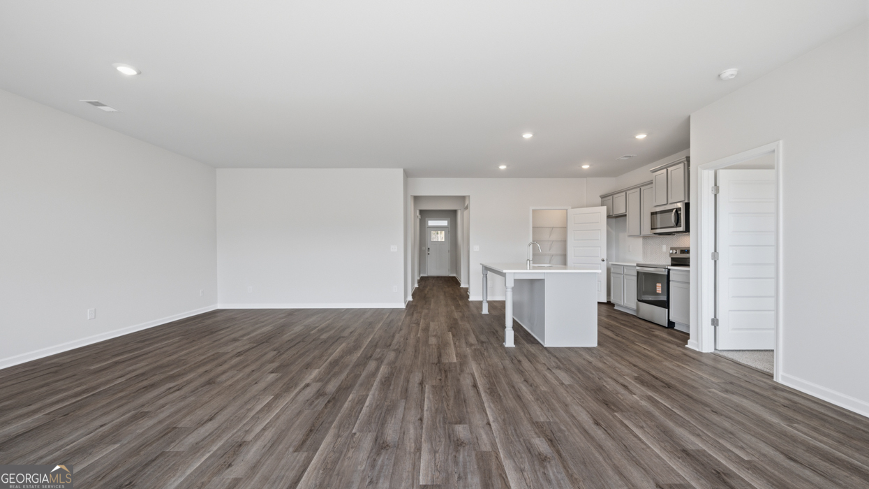 8583 Preakness Pass Snellville, GA 30039 - Photo 22 of 30 a view of a kitchen with furniture and wooden floor