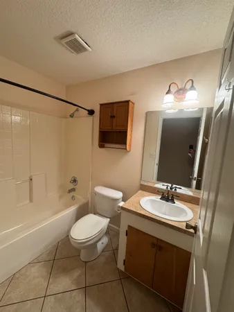 a bathroom with a sink a toilet a mirror and shower