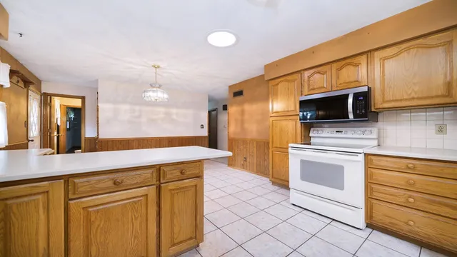 a view of a kitchen with a refrigerator and a stove top oven