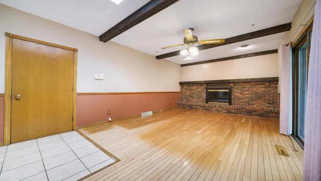 a view of an empty room with glass door and a window