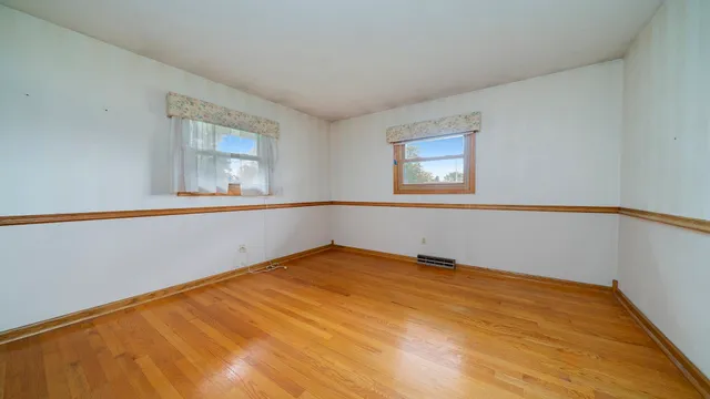 an empty room with wooden floor and sliding door