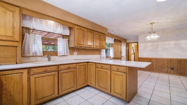 a kitchen with cabinets stainless steel appliances and wooden floor