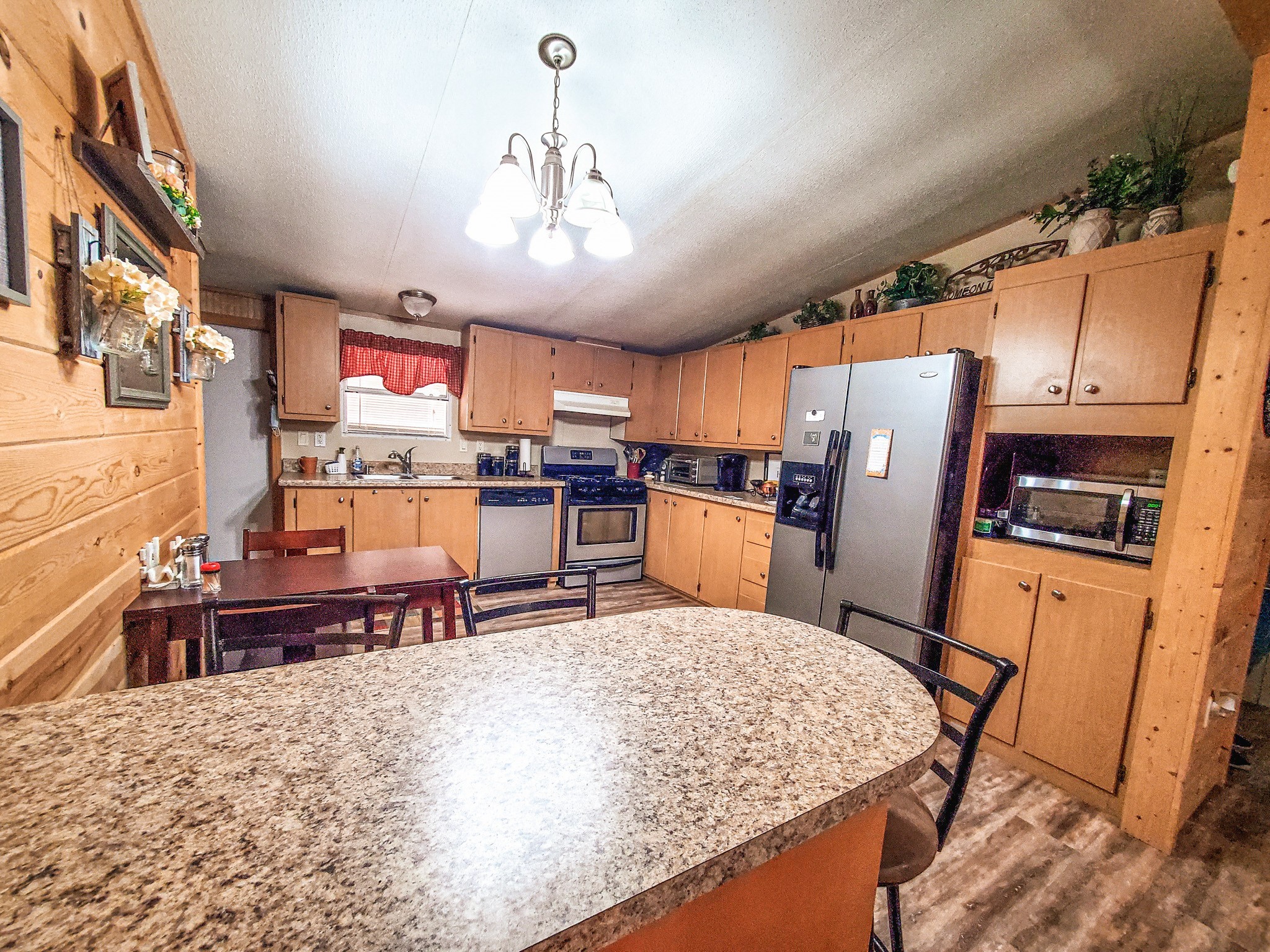 40902 Highway 105 Batson, TX 77519 - Photo 36 of 50 a kitchen with stainless steel appliances kitchen island granite countertop a refrigerator a stove top oven a sink dishwasher and dining table with wooden floor