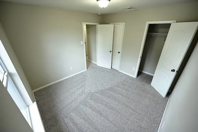 an empty room with an entryway and closet
