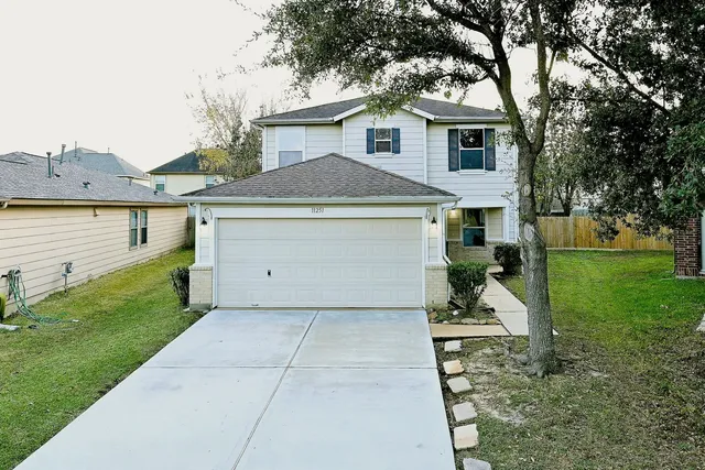 a front view of a house with a yard and trees