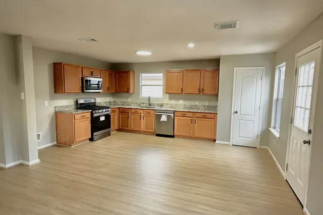 a living room with furniture flat screen tv and a large window