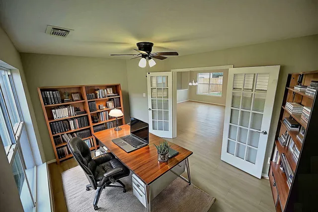 an empty room with wooden floor and windows