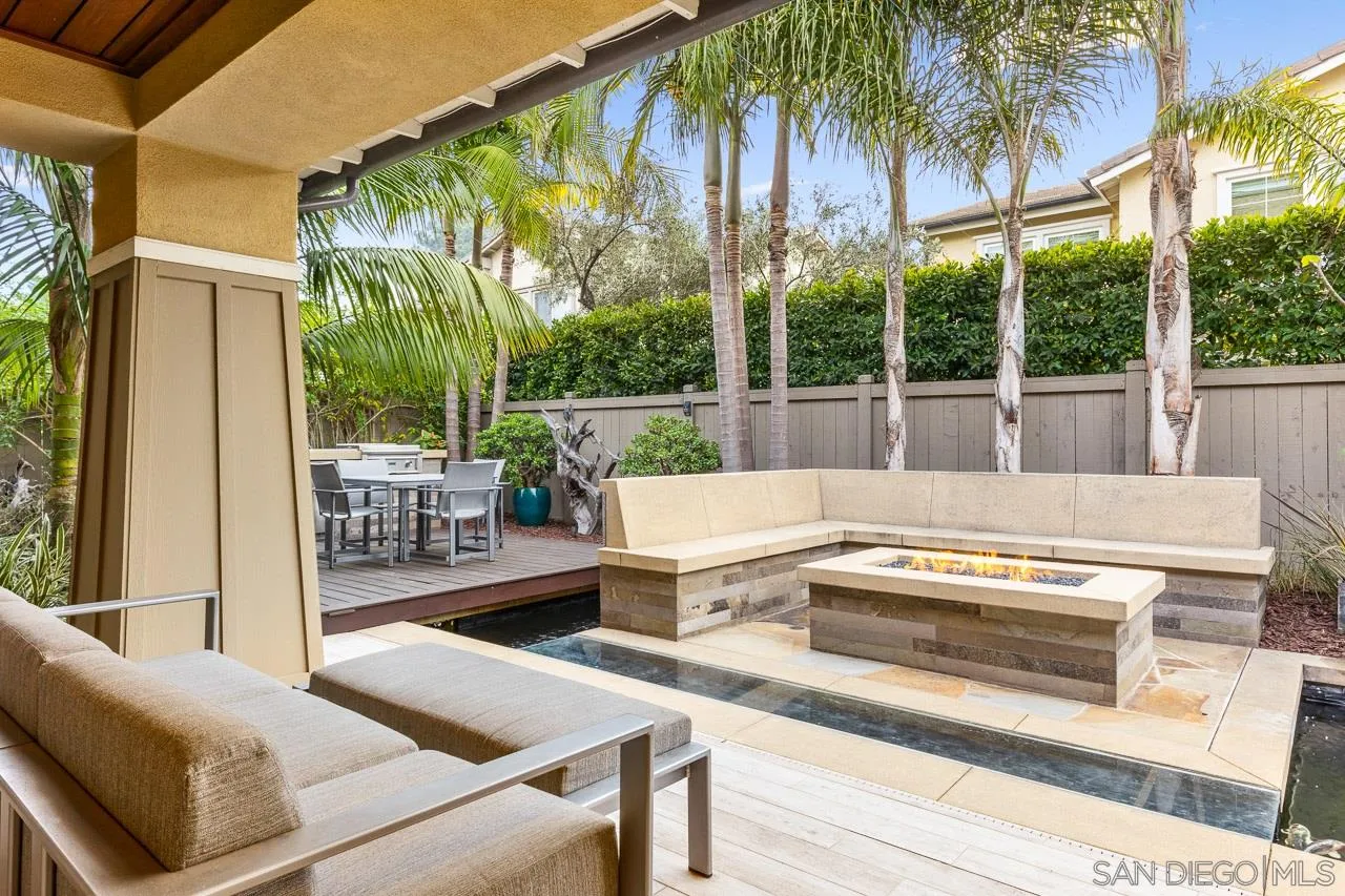 207 Stonesteps Way Encinitas, CA 92024 - Photo 23 of 34 a view of a patio with couches table and chairs under an umbrella
