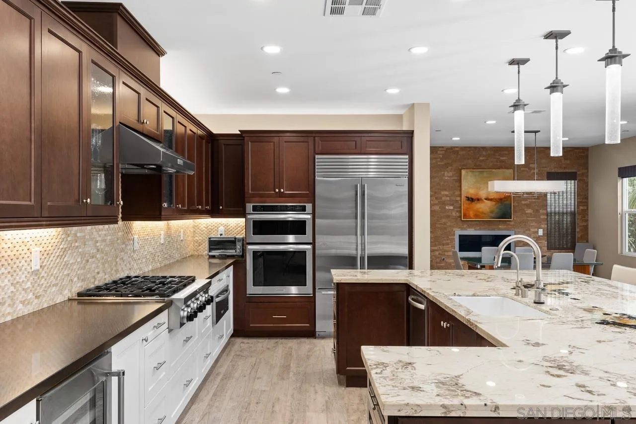 207 Stonesteps Way Encinitas, CA 92024 - Photo 7 of 34 a kitchen with stainless steel appliances kitchen island granite countertop a sink stove and refrigerator