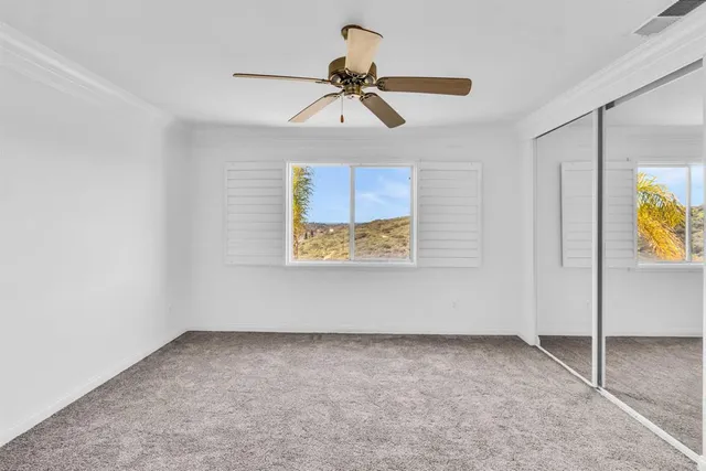 a view of room with ceiling fan and window