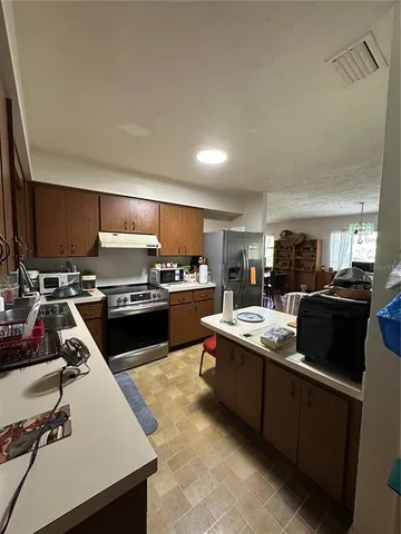 a kitchen with a sink a counter top space stainless steel appliances and cabinets